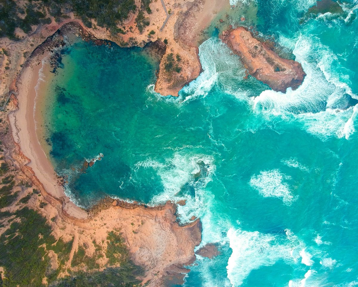 Aerial view of waves breaking around a rocky cove